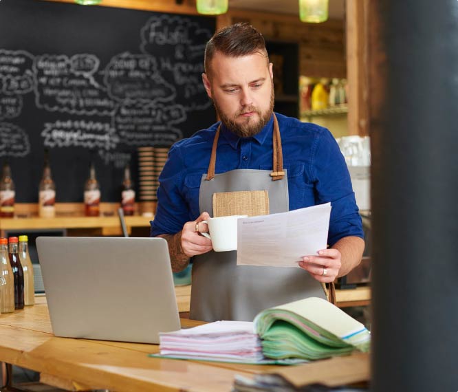 Small business owner reviewing documents for his business savings account