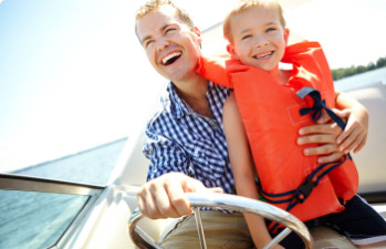 Happy father and son enjoying their boat financed with a boat loan